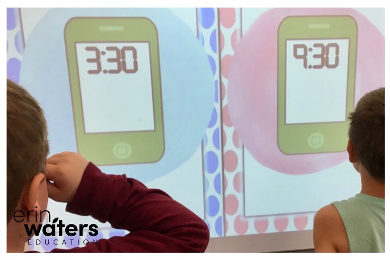 math ideas #2 -play math games (image shows 2 kids facing a whiteboard with mobile phone and digital times shown)